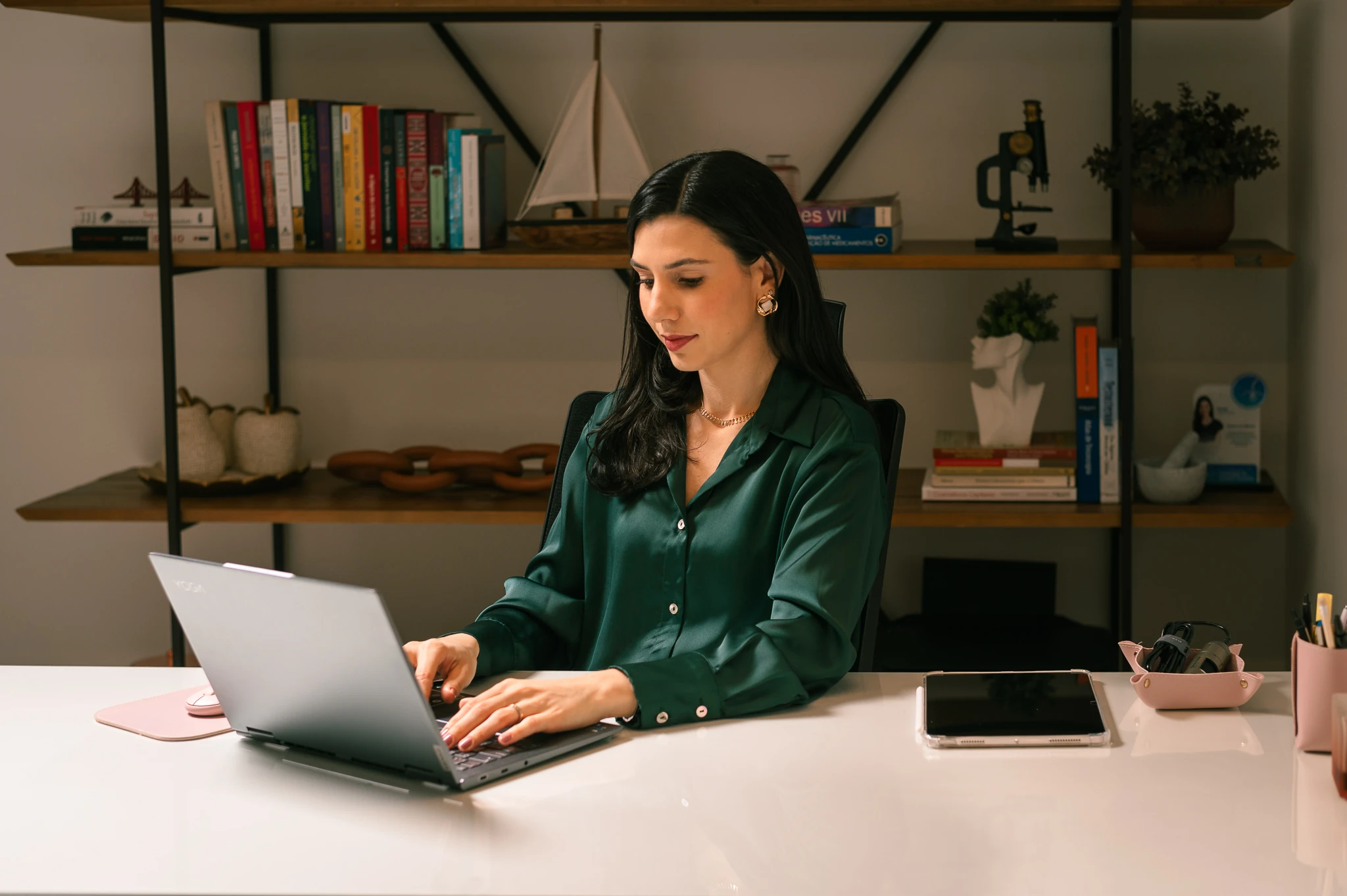 Lívia Viccari em seu ambiente profissional, entre livros e materiais de estudo.