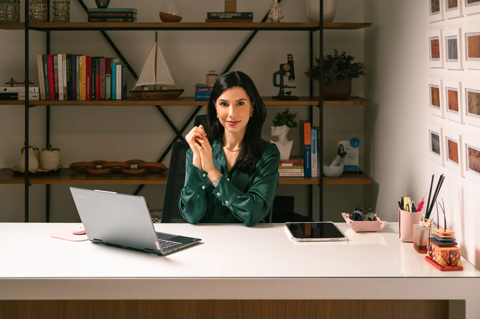 Lívia Viccari à mesa com notebook em ambiente de ensino.