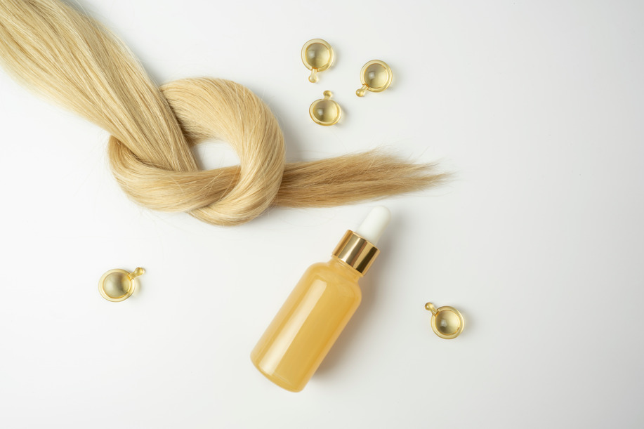 Mercado de trabalho para biomedicina: cabelo loiro e vidro de óleo para tratamento capilar.
