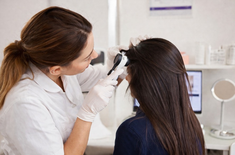 Profissional realizando um exame de tricoscopia.